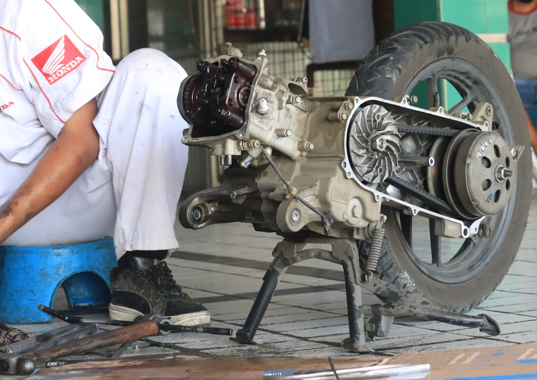 a technician is repairing a motorcycle engine at the Ahas Jatilawang workshop